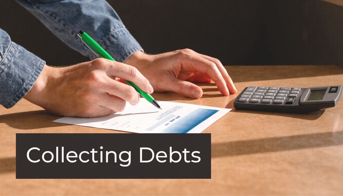 A person writing on a document with a green pen next to a calculator on a desk.