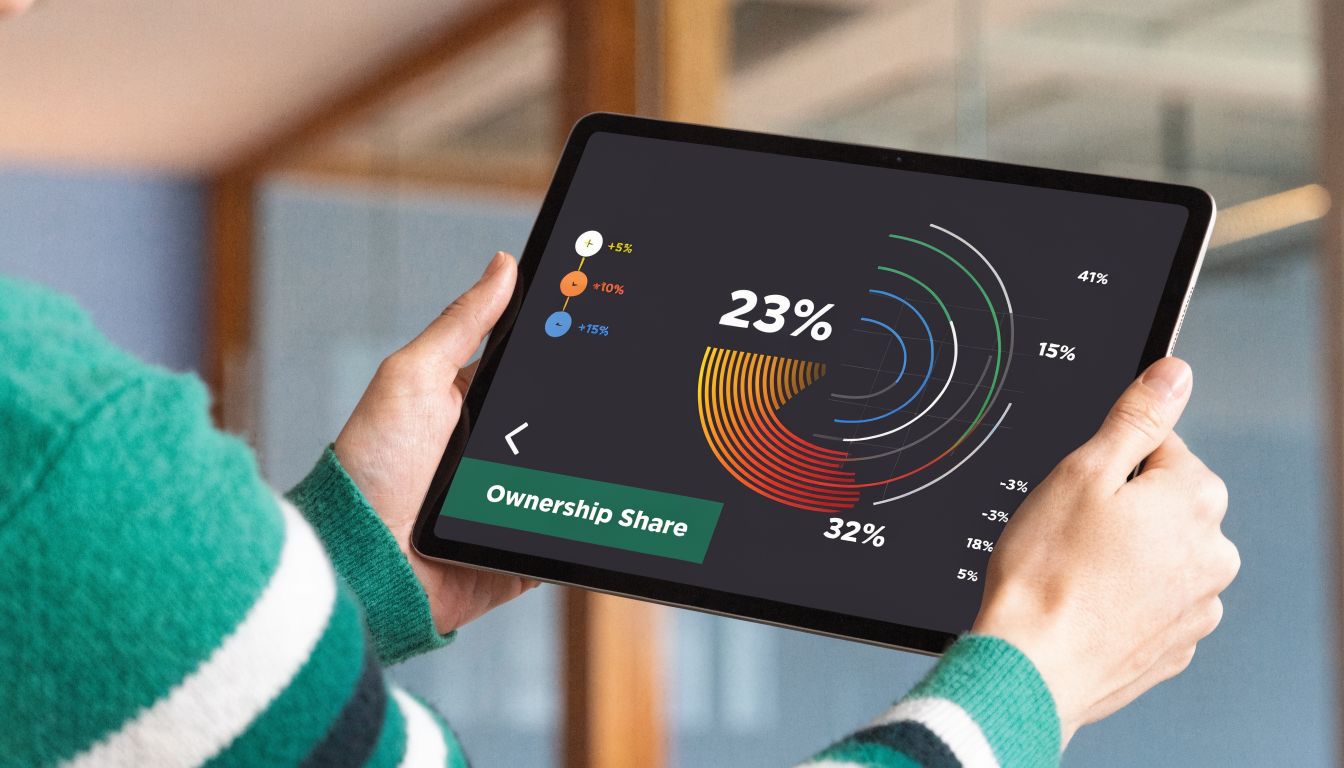 A person holding a tablet displaying a colorful digital ownership share data chart and percentages.